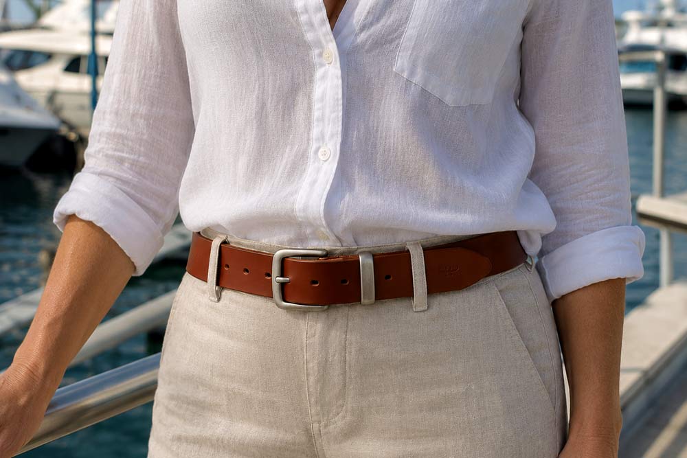 WOMAN-ON-THE-DOCK-WITH-A-FULL-GRAIN-DARK-TAN-LEATHER-BELT-38MM-WIDE WOMAN IN A MARINA WEARING A FULL GRAIN LEATHER BELT IN DARK TAN COLOUR